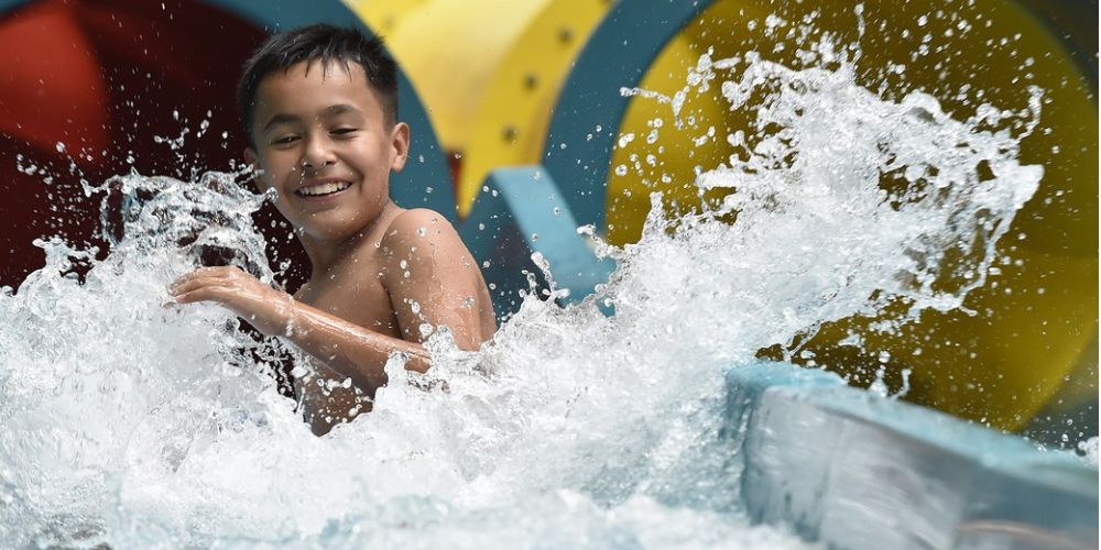 Teen going down a body water slide