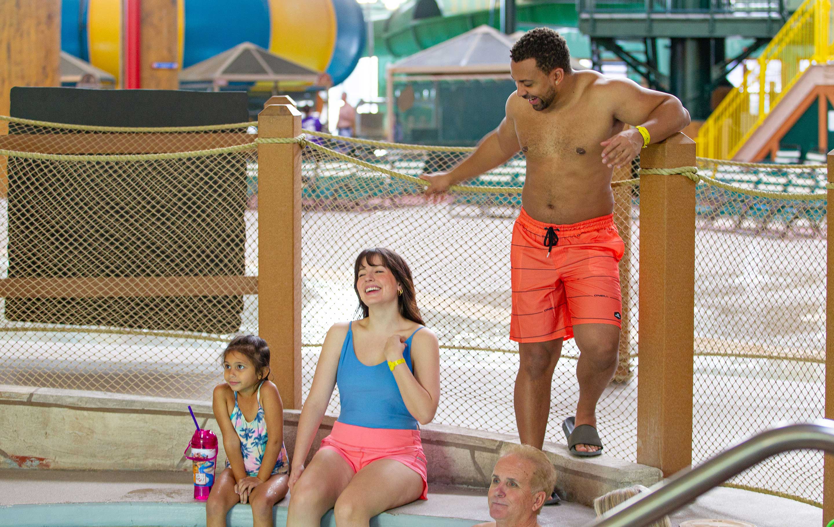 parents and daughter sitting new the hot tub