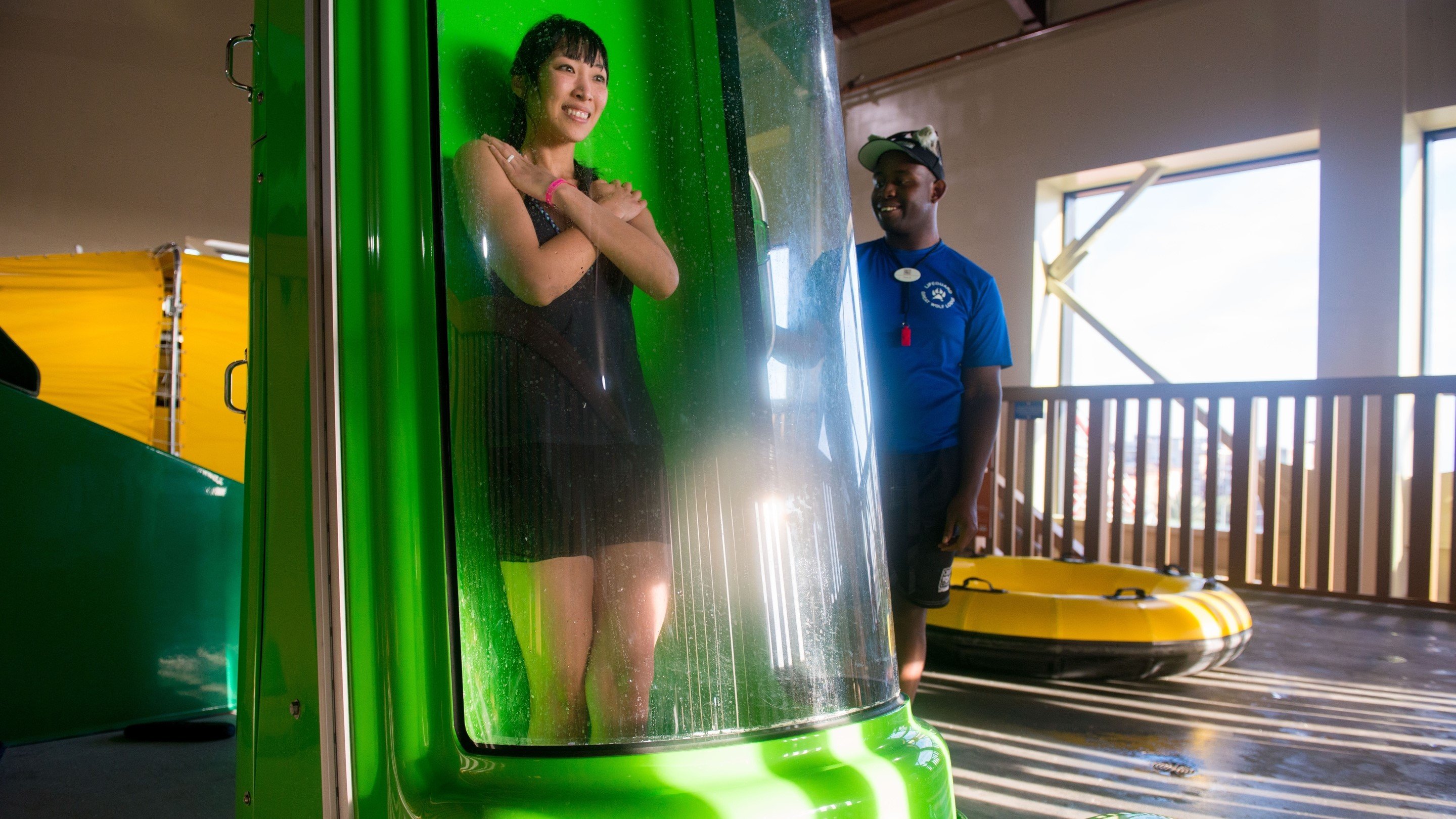 A woman stands in the chute of the Wolf Tail trapdoor waterslide with her arms crossed waiting to take the plunge.